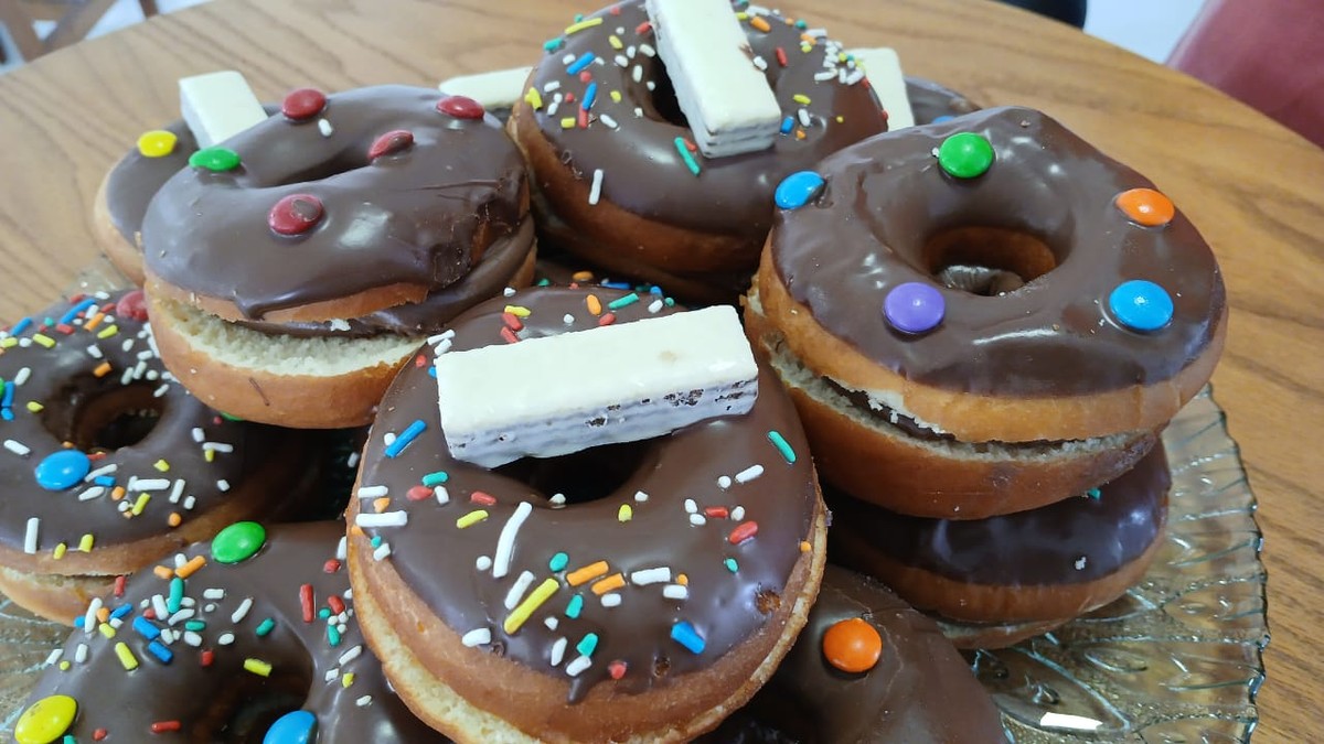 Com cobertura de chocolate e confeitos coloridos, aprenda a preparar Donuts para conquistar o coração da criançada